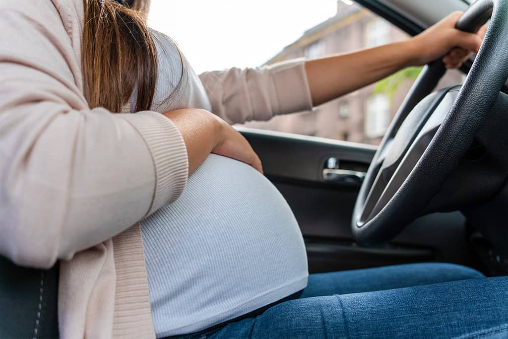 Pregnant woman in the driver seat of a car
