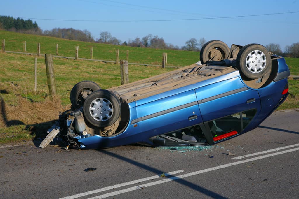 Blue car on its roof after a road accident