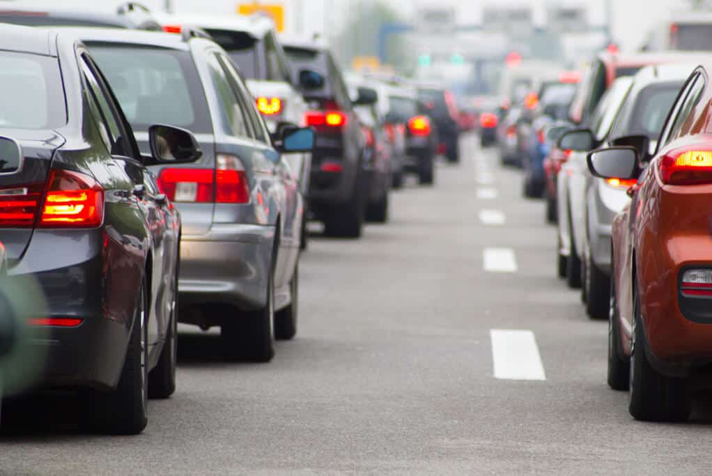 Gridlocked vehicles on a congested road, seen from behind.