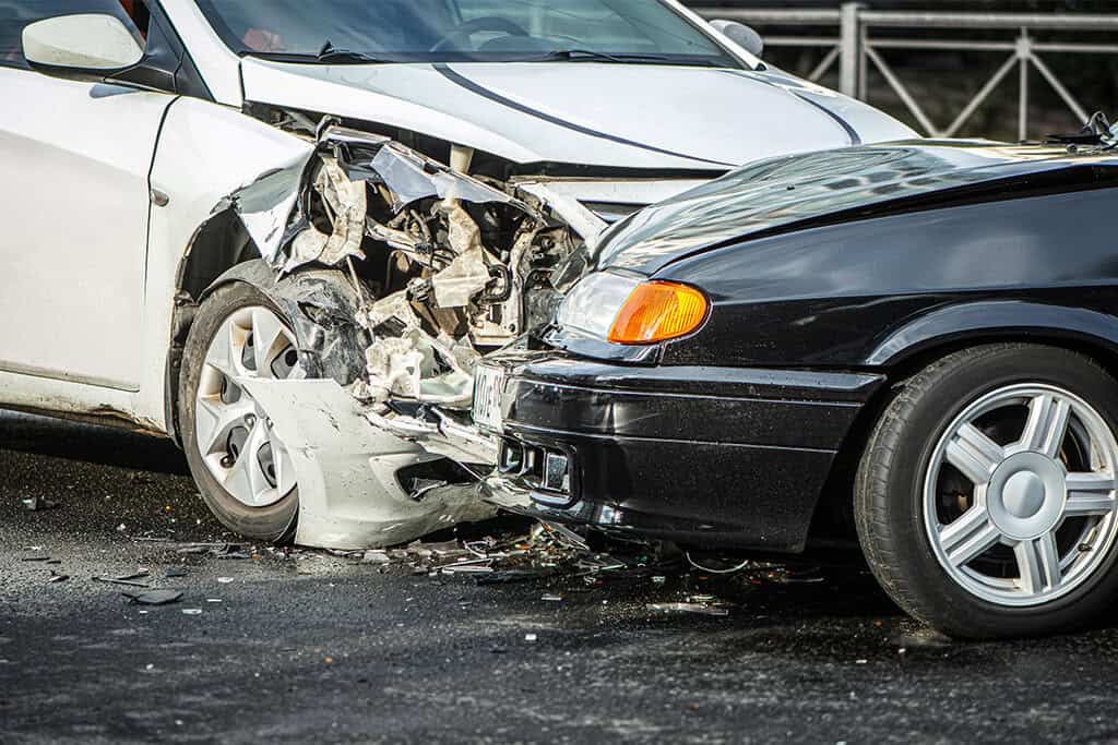 Car accident between black and white vehicals.